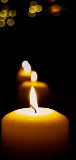 Three glowing candles on a black background.