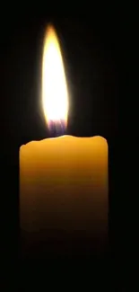 A glowing candle against a black background for a serene mobile wallpaper.