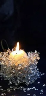 Candle surrounded by crystals on dark background.