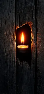 Candle flame glowing through dark wood.