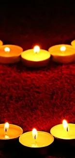 Heart-shaped candle arrangement on a red background, emitting a warm glow.