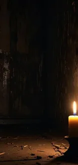 A solitary candle flickers in a dark, shadowy corner.