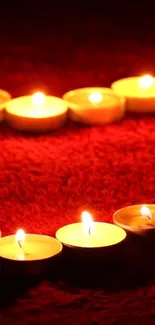 Heart-shaped candle arrangement on a deep red background.