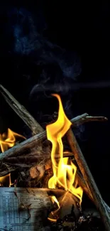 Campfire with glowing flames against a dark background.