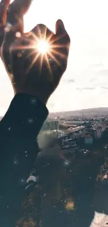 Silhouette of hand in sunlight over cityscape with bright sky.