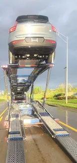 Car transporter on a sunny road with vibrant colors.