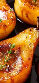 Caramelized pears with herbs on a dark surface.