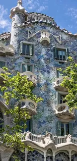 Casa Batlló with vibrant tiles and artistic architecture under a bright blue sky.