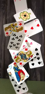 Dynamic cascade of playing cards on wood background.