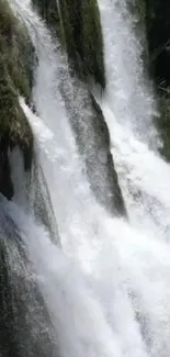 Vivid waterfall cascading over rocks surrounded by lush greenery.