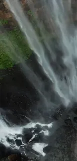 Cascading waterfall against lush green cliffs