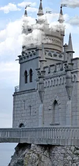 Castle perched on a cliff over the ocean with a serene sky.