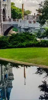 Castle reflected in a tranquil pond amid lush greenery.