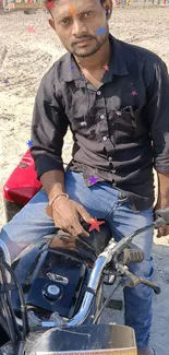 Man sitting on a motorbike on sandy beach with colorful star effects.