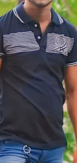 Man in navy blue polo shirt standing outdoors.