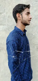 Man in blue shirt side profile on textured wall wallpaper.