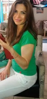 Smiling woman in casual cafe setting with colorful decor.