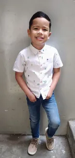 Young boy in casual jeans and a white shirt, standing on stairs.