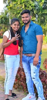 Couple in park with lush greenery and casual style.