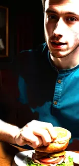 Young man enjoying a burger in warm lighting.