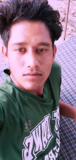 Young person in green shirt, casual outdoor portrait.