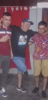 Three friends posing indoors in casual attire.