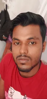 Casual portrait of a young man in a red shirt indoors.