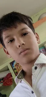 Portrait of a young boy in a casual indoor setting with vibrant colors.