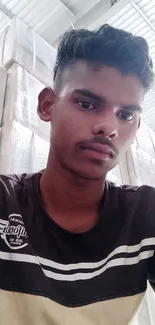 Young man in casual attire with light grey background indoors.