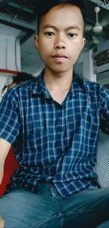 Casual portrait of a young man in a stylish blue shirt.