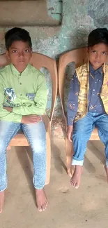 Portrait of two kids sitting on chairs in a rustic indoor setting.