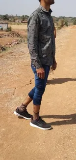 Person walking on a rustic path in casual attire.