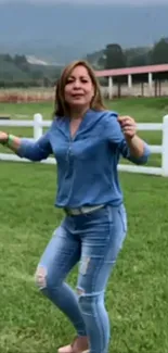 Woman dancing casually in a green field.