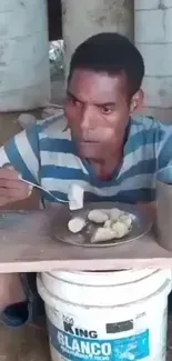 Man enjoying a meal outdoors with a serene backdrop.