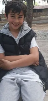 Young boy in casual wear, sitting on a park bench.