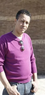 Outdoor portrait of a man in a purple sweater with sunglasses.