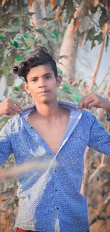 Casual portrait of a young man outdoors with a blue shirt.