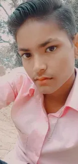 Young person in pink shirt outdoors.