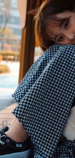 Casual portrait of a woman sitting outdoors with a serene expression.