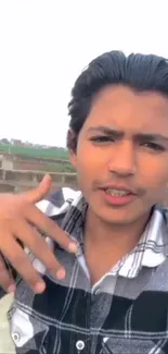 Young man taking a selfie outdoors with a casual and stylish look.