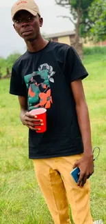 Young man in stylish attire in a vibrant grassy field.