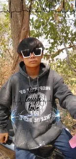 Stylish individual with sunglasses and hoodie outdoors.