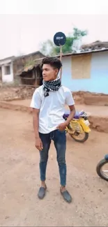 Casual man standing in rustic village outdoor setting.