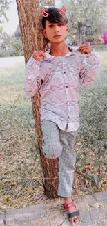 Casual young person posing outdoors with nature background.