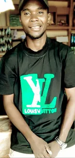 Man in a black tee with green logo, casual look.