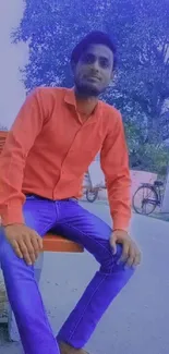 Person in vibrant outfit sitting on a bench.