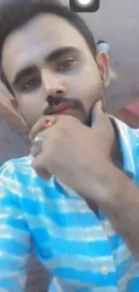 Thoughtful man in blue striped shirt posing casually.