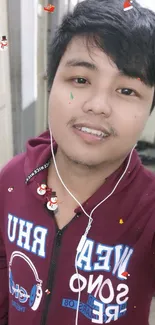 Portrait of person in maroon hoodie in hallway setting.