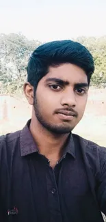 Casual portrait of a young man with a scenic background.