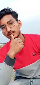 Casual portrait in outdoor natural setting, red and gray attire.